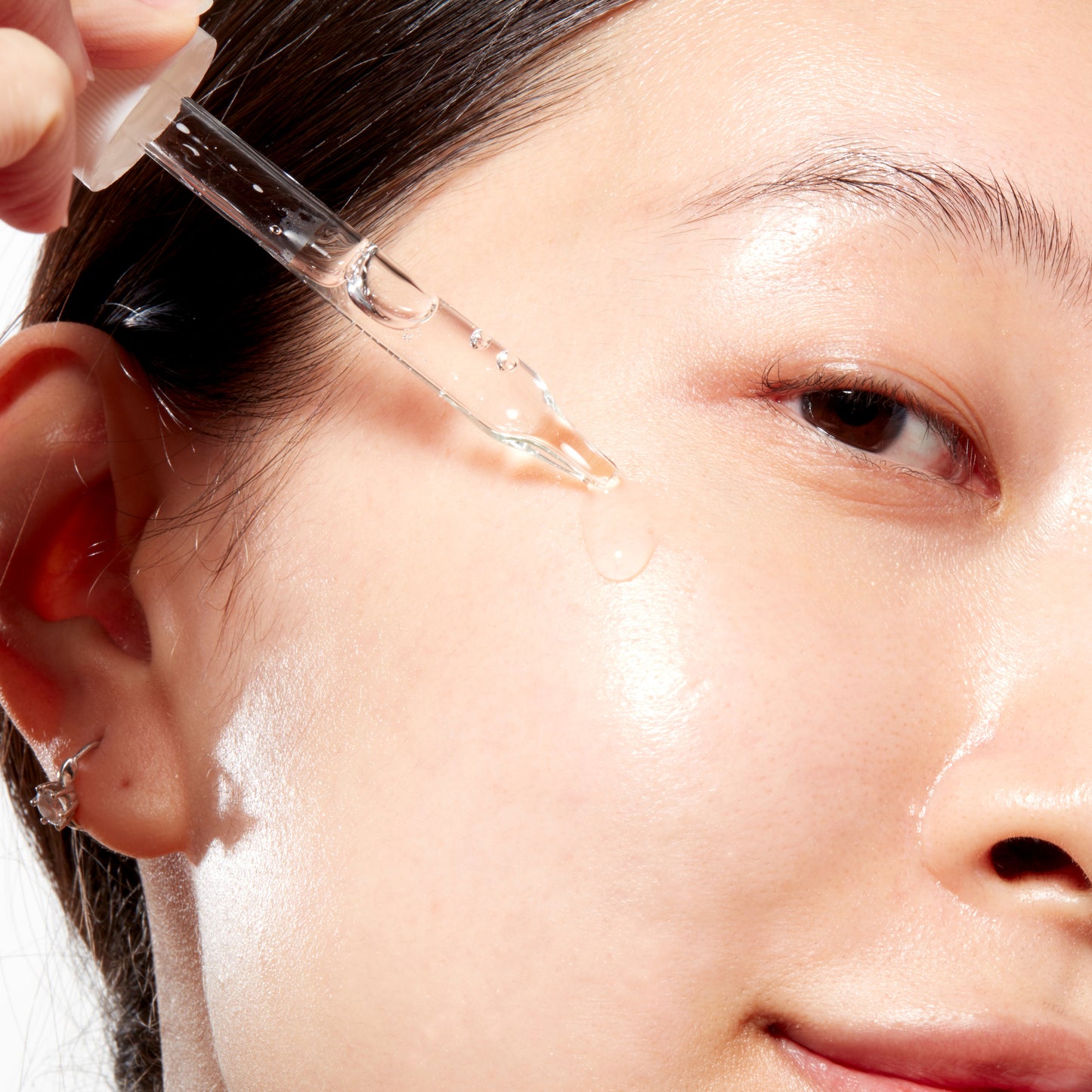 Woman demonstrating how to apply Peptide Renewal Serum