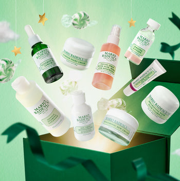 Collection of Mario Badescu skincare products on a green background