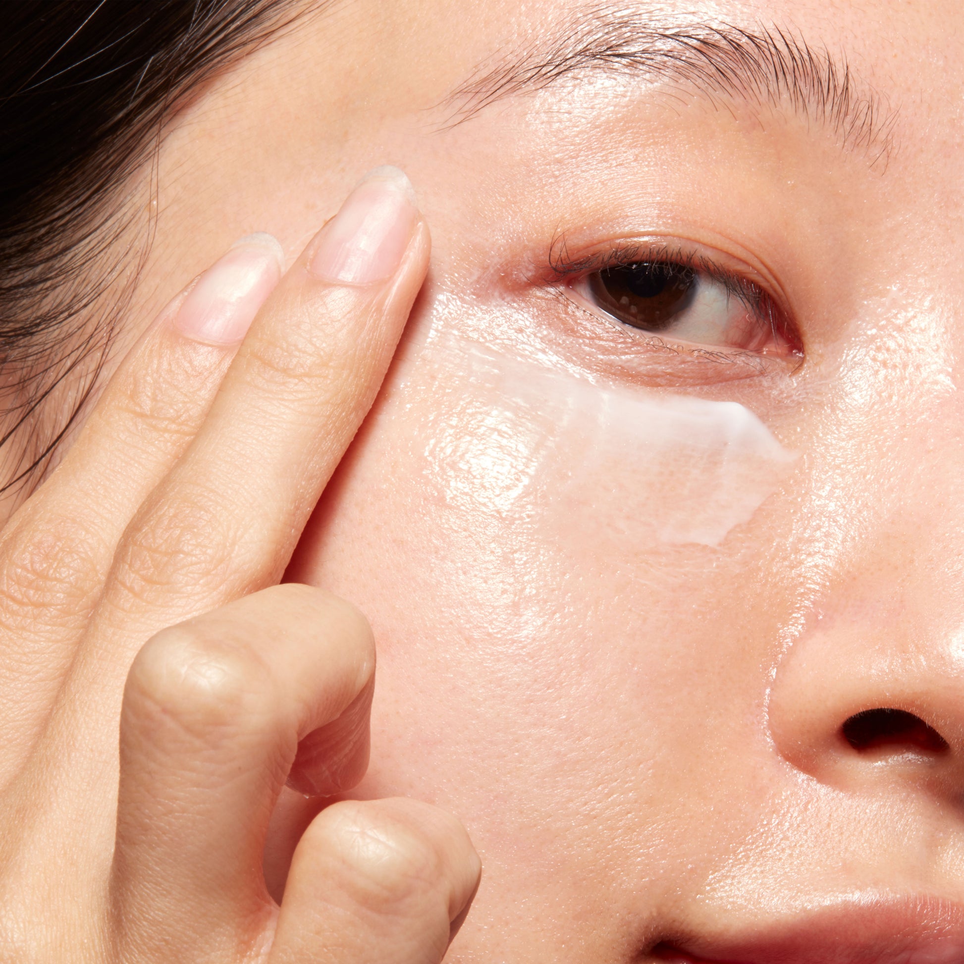 Woman demonstrating how to apply Caffeine Eye Cream