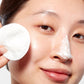 Woman demonstrating how to apply Silver Powder on her nose with a cotton pad