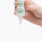 Demonstration showing a woman's hand squeezing Buffering Lotion