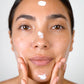 Woman demonstrating how to apply Peptide Renewal Cream